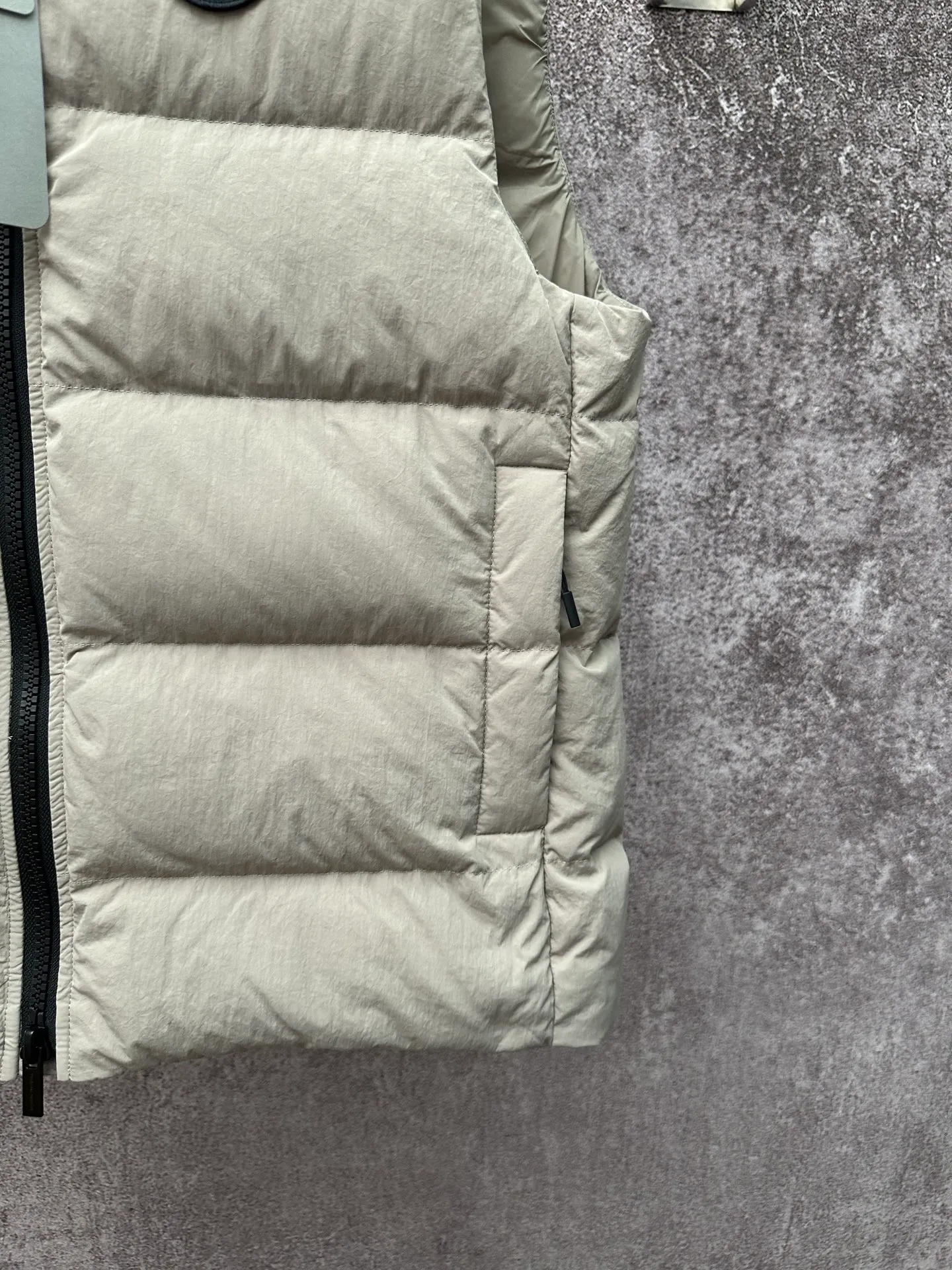 P720 Canada Goose Badge Down Vest Fabric selection: The use of high-quality protective nylon fabric not only enhances the wear resistance of the surface, but also takes into account wind resistance, ensuring excellent performance in various harsh weather conditions.  90 national standard high-quality white duck down: selected high-loft down, weighing 160g, light and warm, with excellent temperature locking performance and good resilience.  Three-dimensional quilting process: Precision thread reinforcement to prevent velvet drilling and ensure that the fluffy and resilient elasticity lasts as new.  Details: The ribbon is woven with polyester as the base, and the brand letters are decorated on the ribbon through high-precision computer embroidery. The edges of the pattern are clear, the stitches are fine and even, and multiple layers of embroidery thread are stacked to enhance the three-dimensional effect. Accessories: One-to-one customized logo, one-to-one customized zipper puller, one-to-one customized three-label SIZE: S M L XL